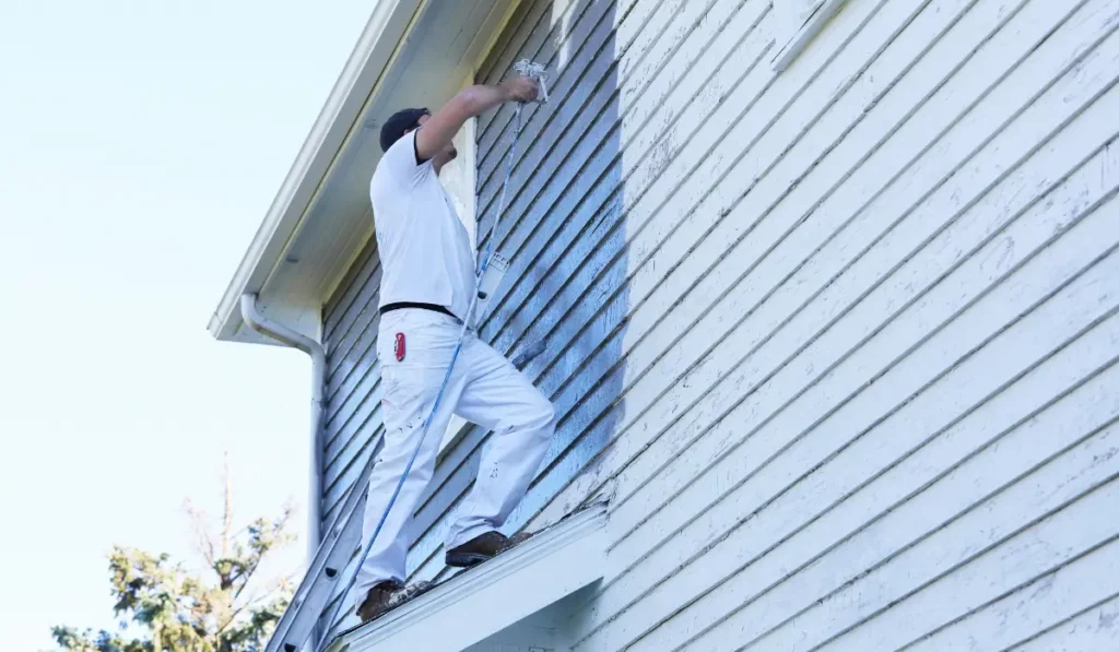 Exterior painting on cold-season wood siding using professional tools and prep work for cold conditions.