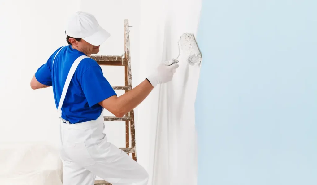 Professional painter applying white low-VOC paint to an interior wall in a Naperville home.