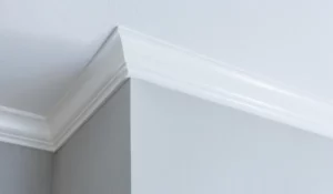 Crown molding painting showing clean trim and ceiling transition under lighting that reveals imperfections
