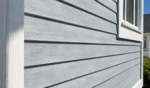 Sunlight strikes blue siding where Exterior Paint and Wood Stain face prolonged ultraviolet exposure on homes.